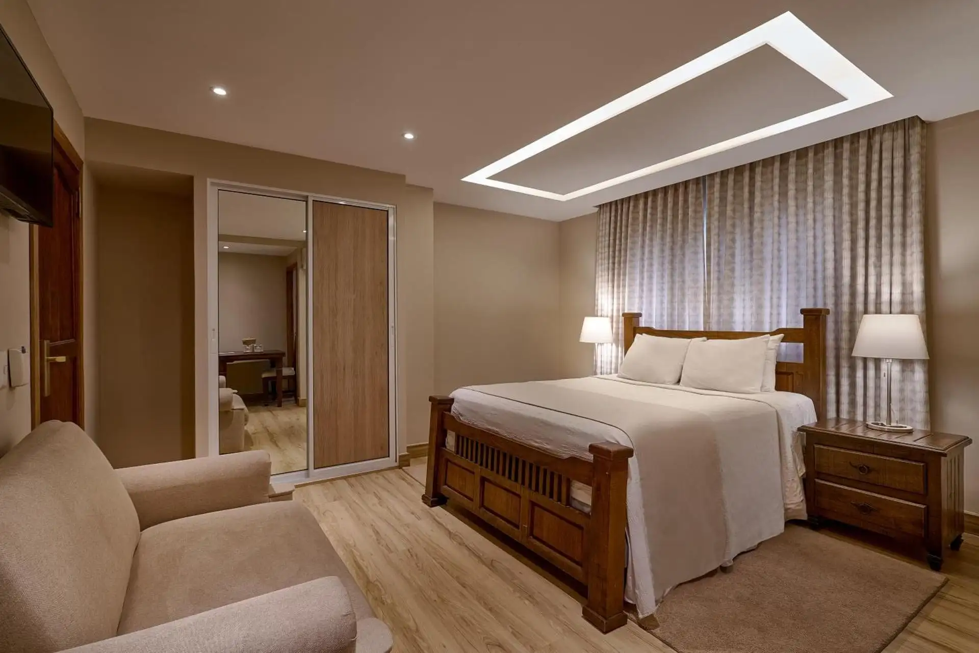Habitación Doble con cama queen, sofá y armario con espejo
