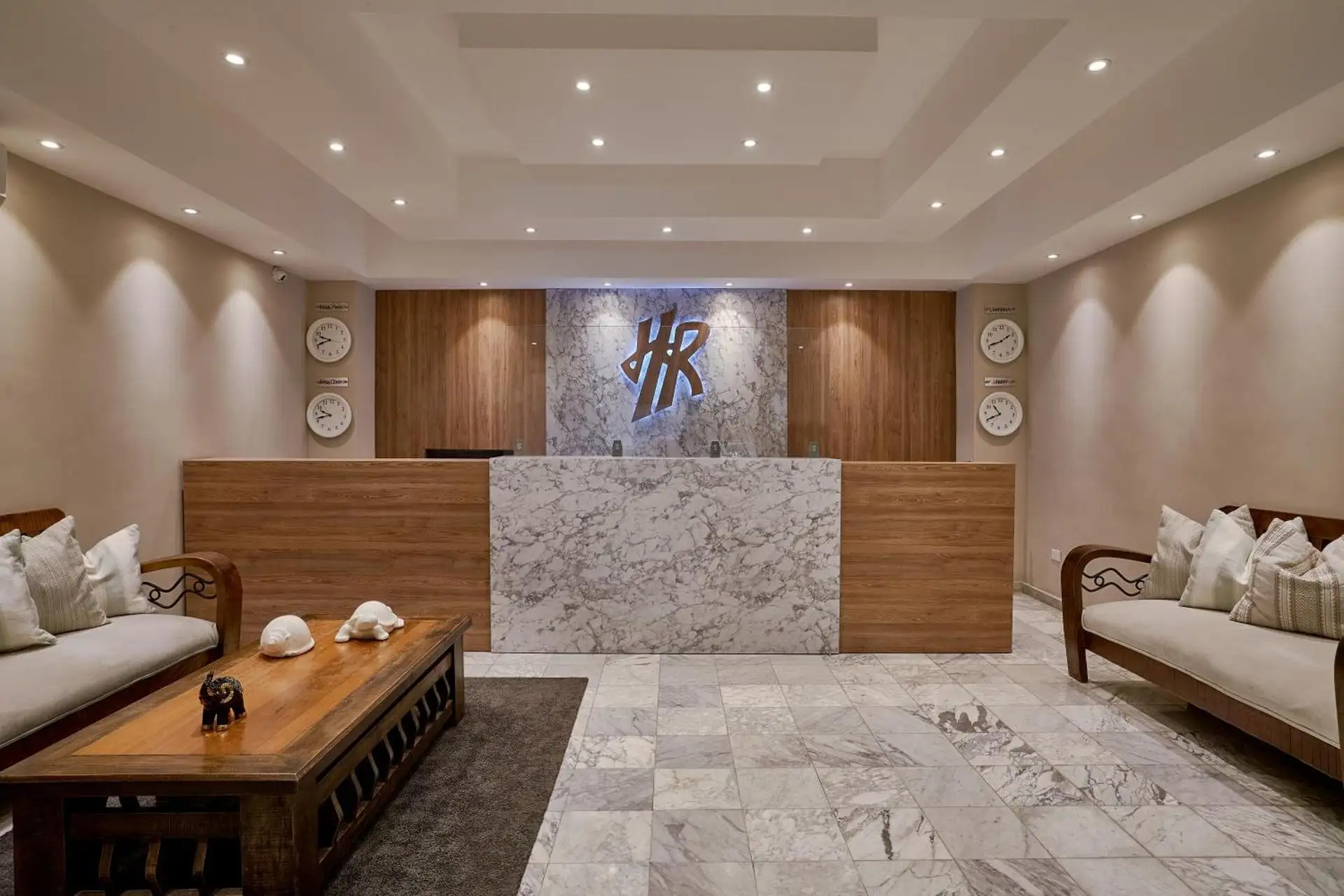 Recepción del Hotel Riazor con mostrador de mármol y logo HR